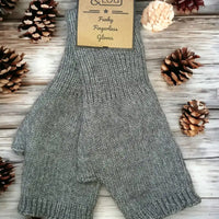 A pair of gray knit fingerless gloves laid flat on a whitewashed wood surface, with pinecones around them and a paper tag reading 'O'Leary Funky Fingerless Gloves.'.