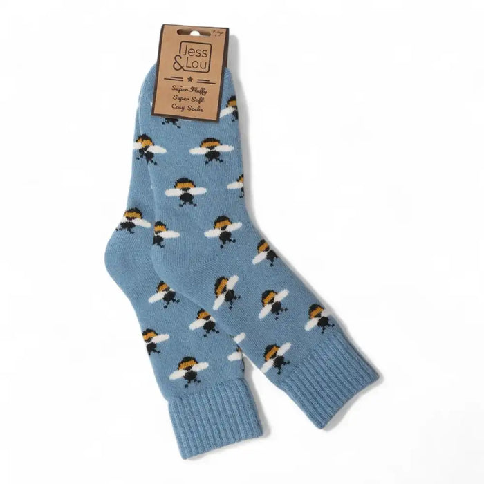 A pair of light blue crew socks with a repeating bumblebee pattern, attached to a brown paper brand tag, shown on a plain white background.