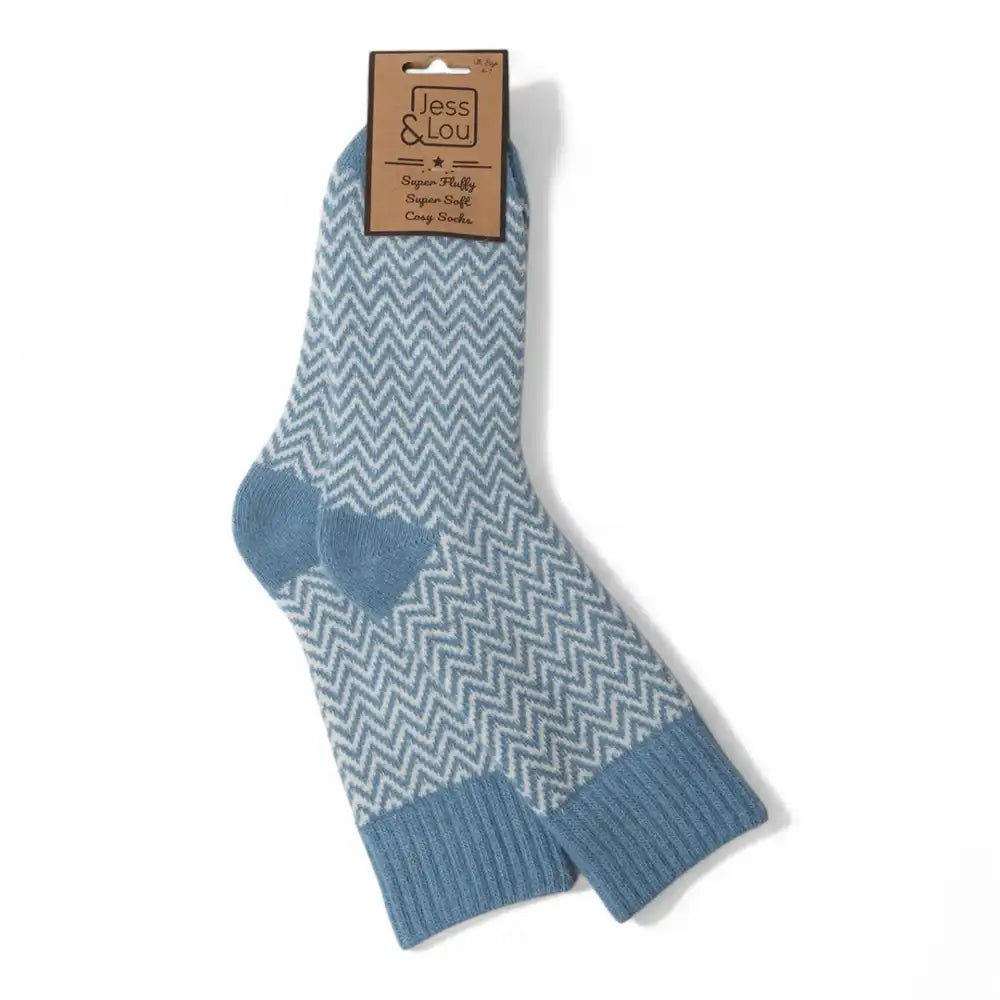 A pair of blue and white chevron-patterned crew socks with solid blue ribbed cuffs and heels, hanging from a brown paper tag that reads 'Jess & Lou'.