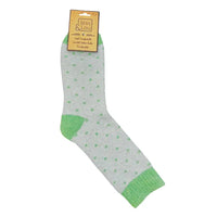 A single sage green sock with green dotted pattern and green toe/heel/cuff accents, attached to a tan paper hanger label that reads Jess & Lou, on a plain white background.