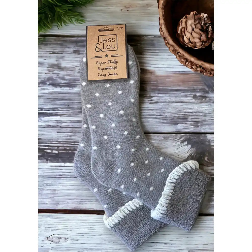 Pale grey small white dotted sock with a turned down ankle cuff that has a white trim.