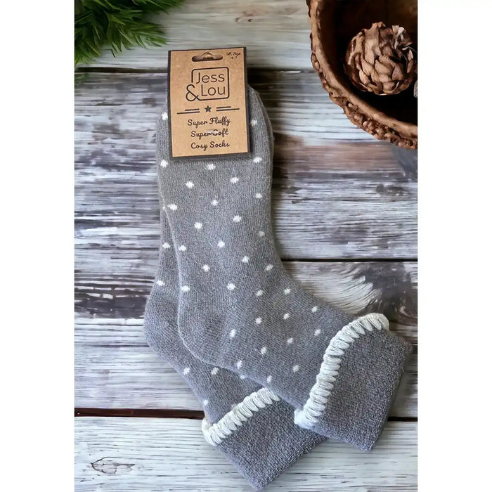 Pale grey small white dotted sock with a turned down ankle cuff that has a white trim.