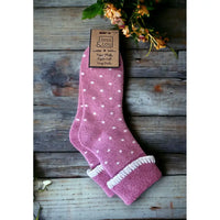 Pale pink small white dotted sock with a turned down ankle cuff that has a white trim.