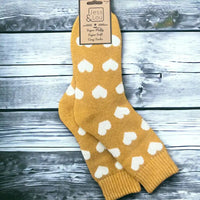 Yellow background sock with large white hearts and ribbed ankle cuff