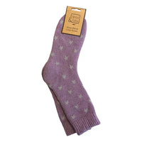 A pair of purple wool blend cozy socks with a pattern of small grey stars, shown on a plain white background with a paper hang tag.