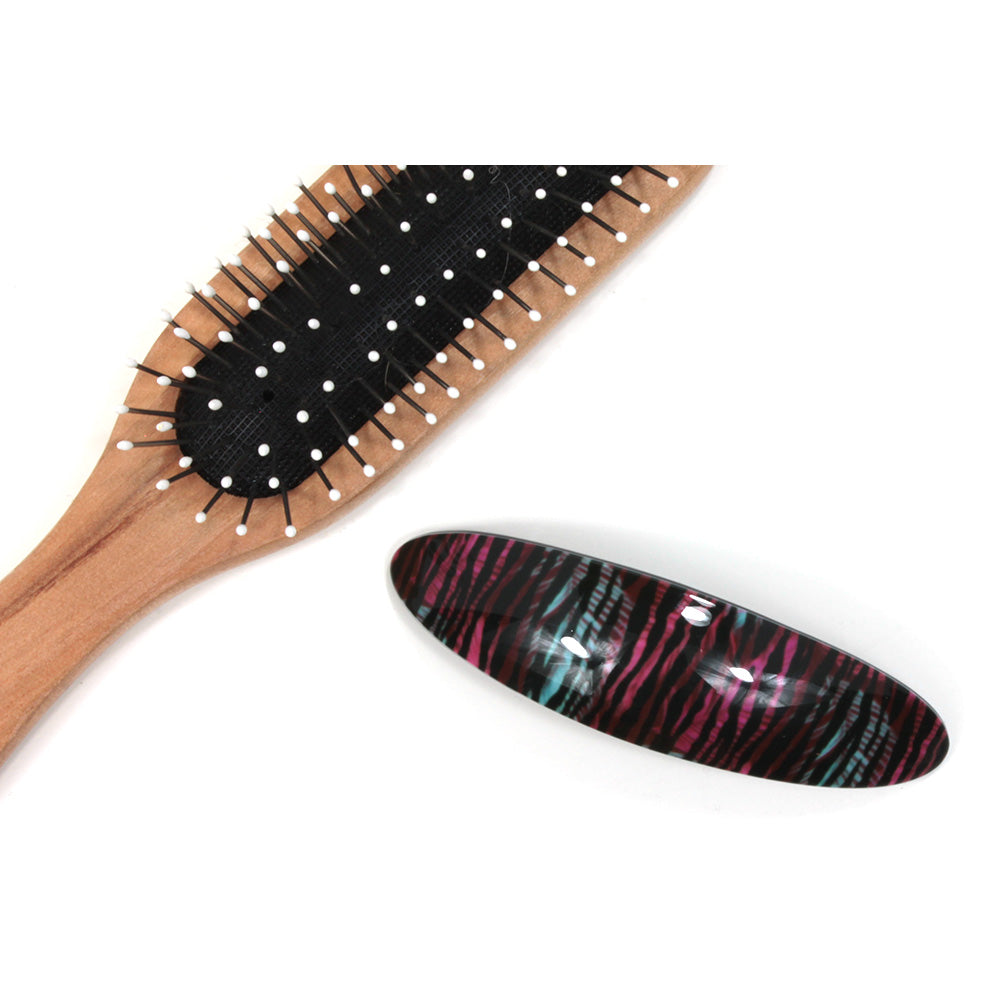 Crimson and teal animal pattern plastic elongated hair clip. Hairbrush pictured for size illustration.
