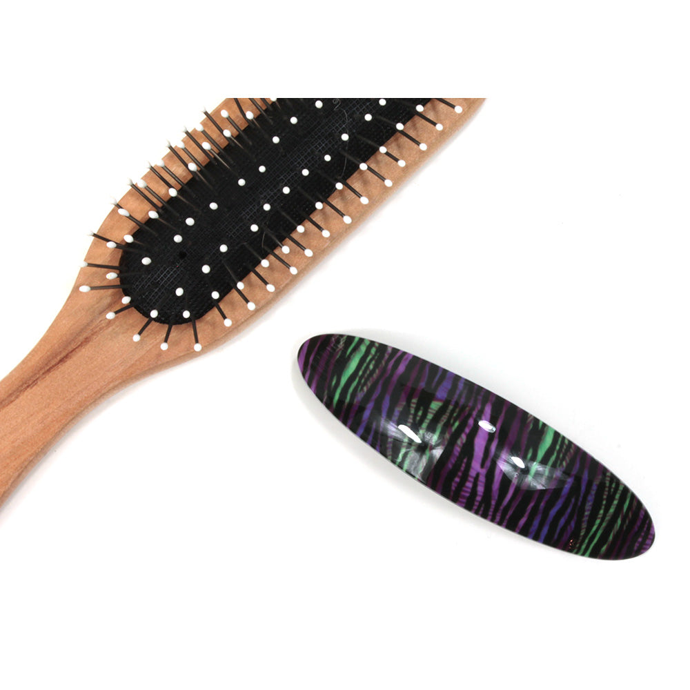 Purple and green animal pattern plastic elongated hair clip. Hairbrush pictured for size illustration.