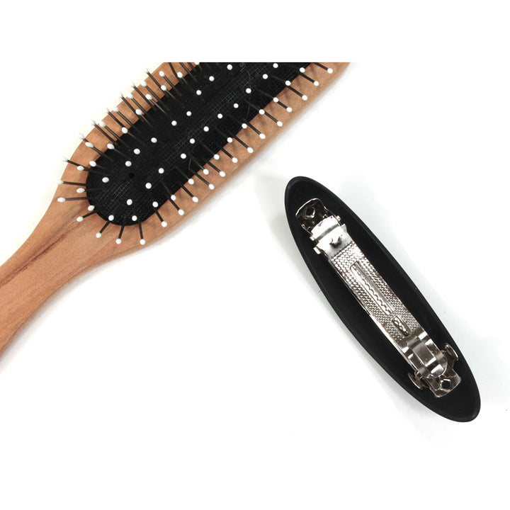 Plastic elongated hair clip. Back showing metal clip. Hairbrush pictured for size illustration.