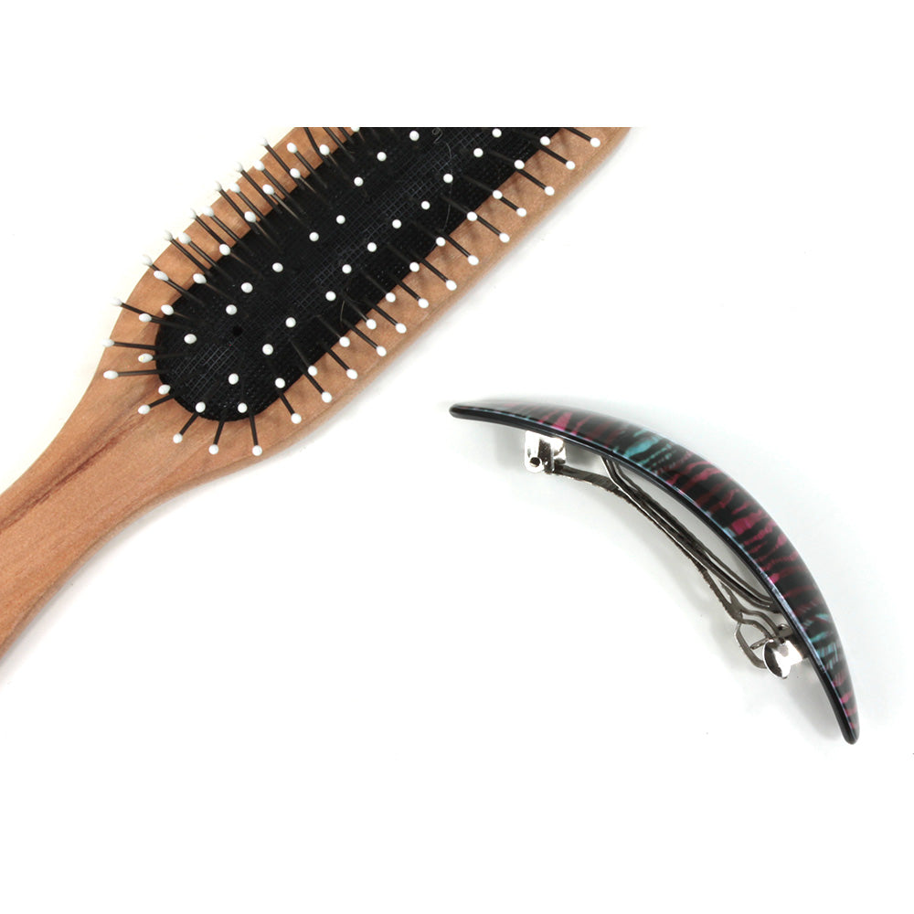 Plastic elongated hair clip. Side view.  Hairbrush pictured for size illustration.