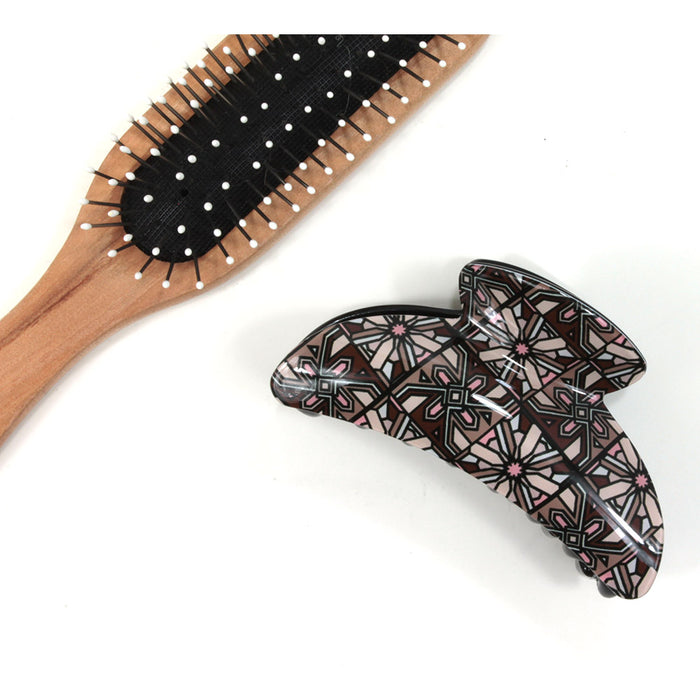 Art Deco hair claw with beige and brown based pattern. Brush shown for scale.