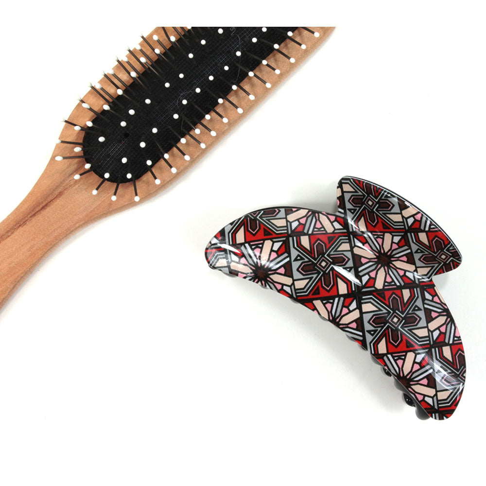 Art Deco hair claw with red based pattern. Brush shown for scale.