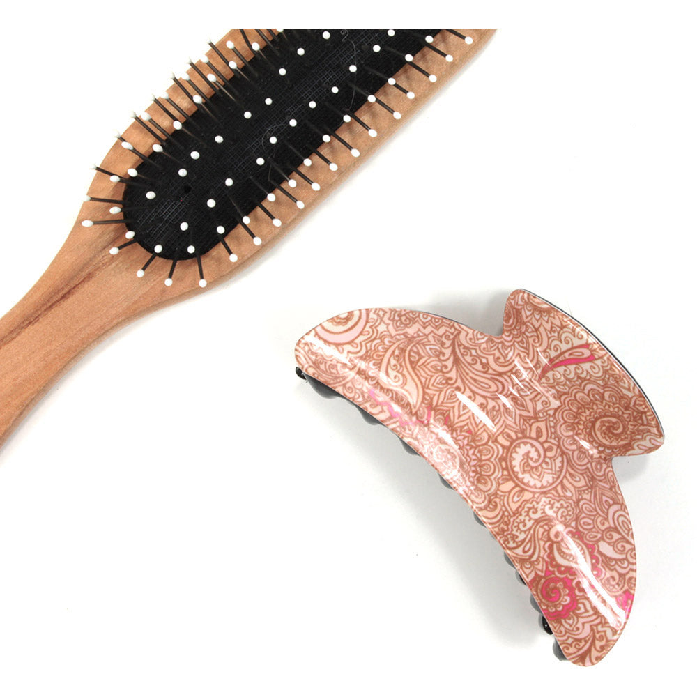 Paisley hair claw with beige based pattern. Brush shown for scale.