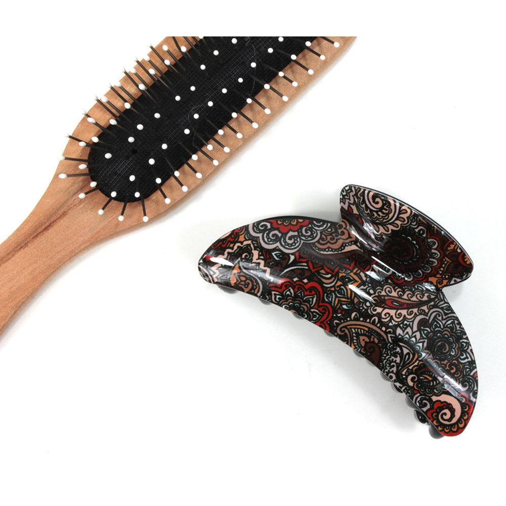 Paisley hair claw with peach based pattern. Brush shown for scale.