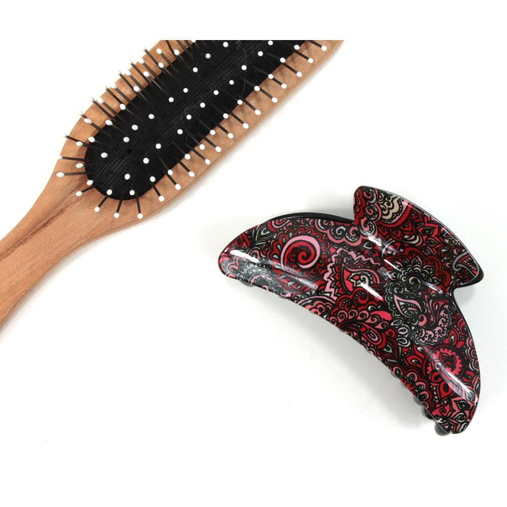 Paisley hair claw with red based pattern. Brush shown for scale.