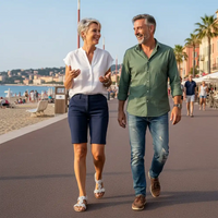Man and woman walking along a beach promenade with a scenic background
