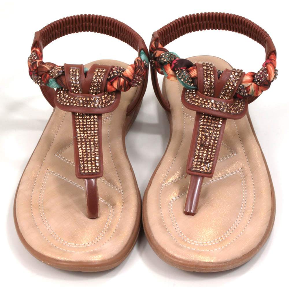 Tan coloured toe post sandals with elasticated back. Jewels and fabric decoration. Light tan coloured insoles. Front view.