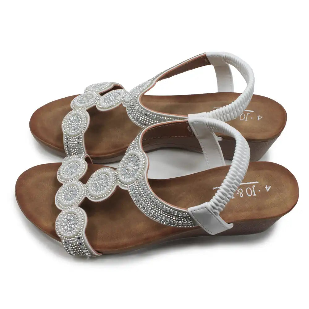 Pair of sandals with decorative straps on a white background