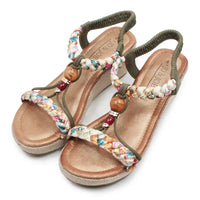 Pair of sandals with colorful beaded straps on a white background