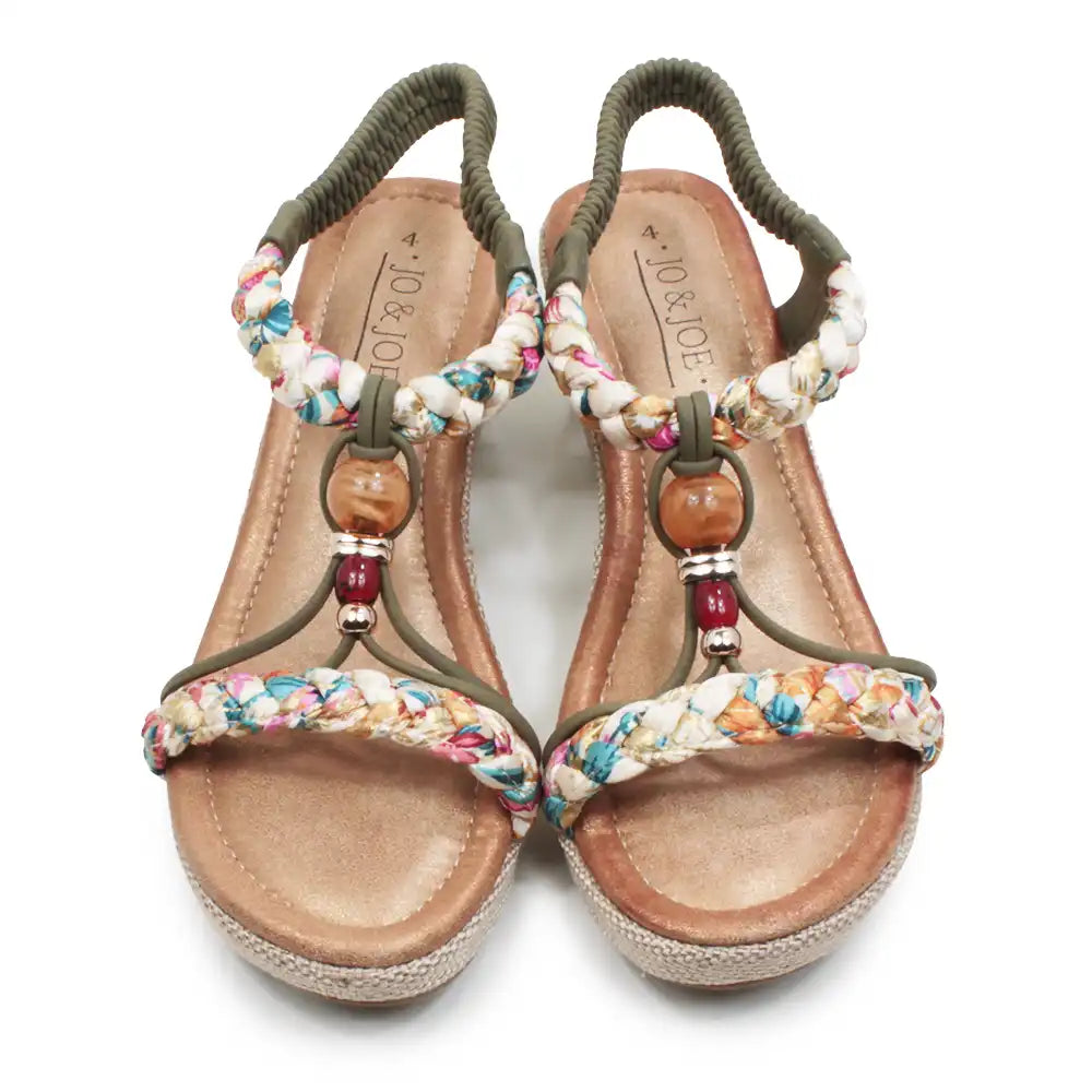 Pair of sandals with floral straps and wooden beads on a white background