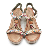 Pair of sandals with floral straps and wooden beads on a white background