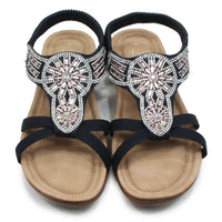 Black sandals with decorative straps on a white background