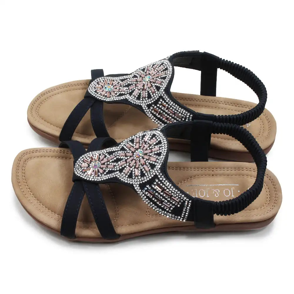Pair of embellished sandals with black straps on a white background