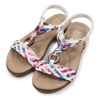 Beige sandals with colorful braided straps on a white background