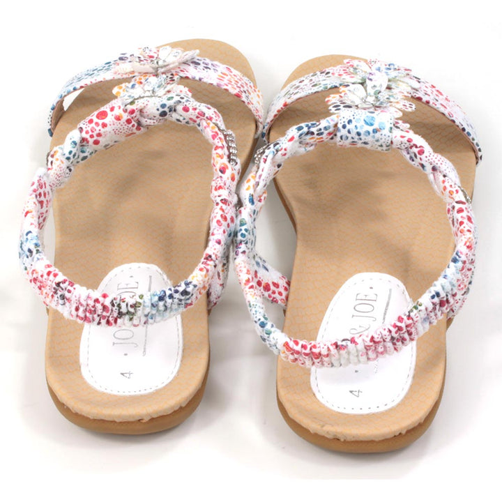 Flat sandals with white straps decorated with multi coloured pattern. Floral detailing over the feet. Elasticated heel straps. Back view.
