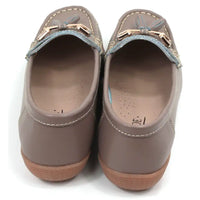 Pair of beige moccasins  with decorative gold bars and tassels on a white background