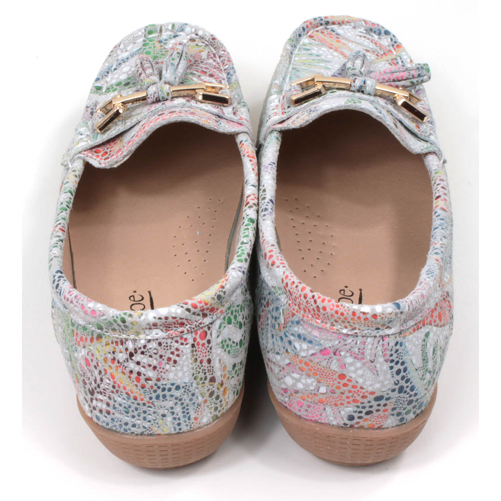 Jo and Joe Rio mocassin style slip on shoes. White background with floral mosaic style design. Gold bar and tassels details on foot. Back view