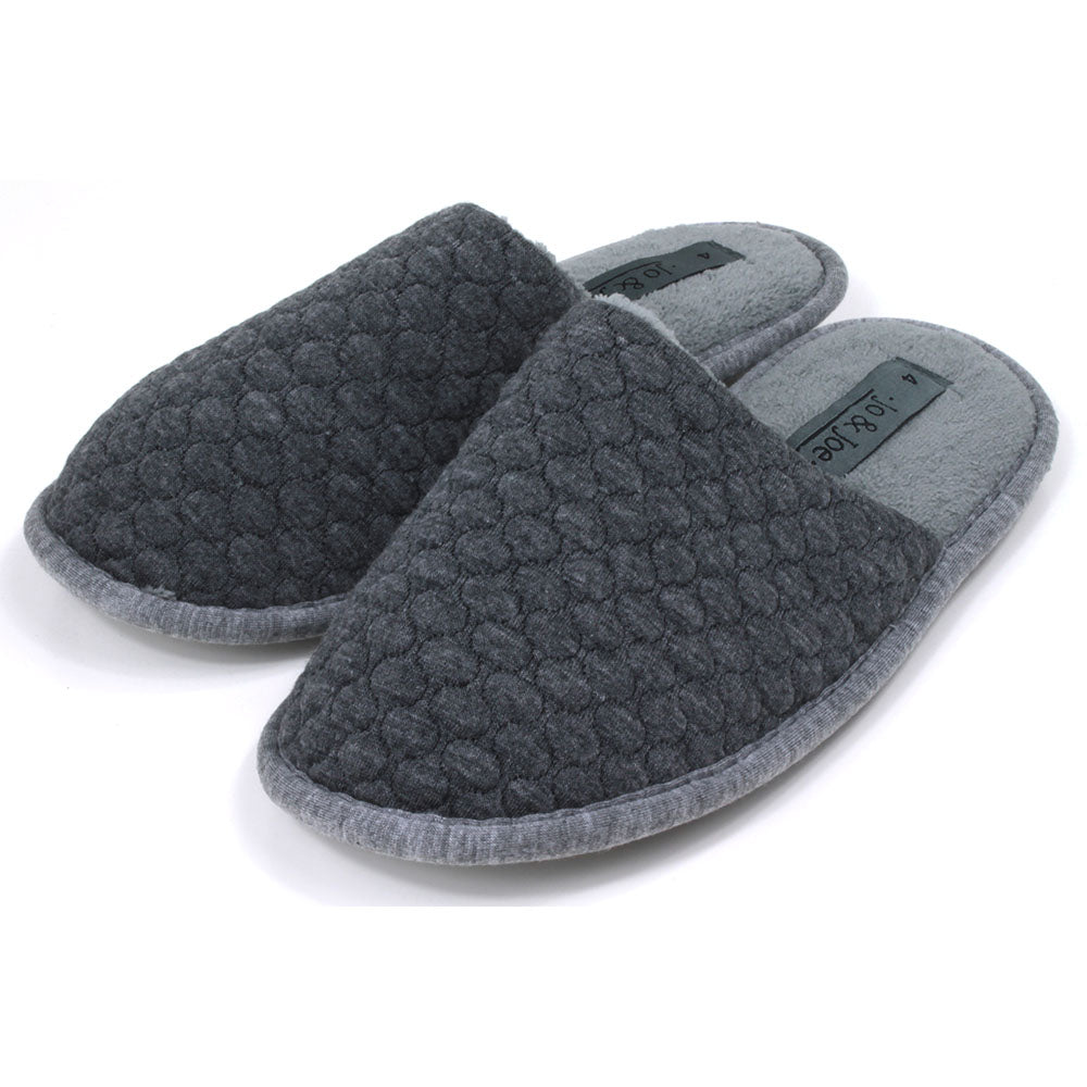 Grey mule slippers with sculpted waffle fabric. Lighter grey footbed and fabric around the soles. Angled view. 