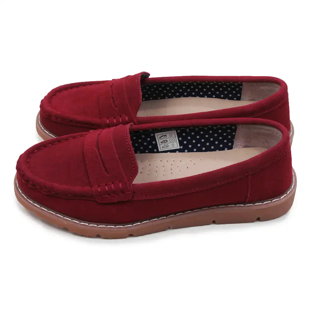 Red loafers with a polka dot interior on a white background