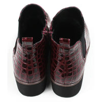 Pair of burgundy crocodile-patterned boots. Back view.