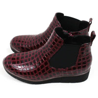 Pair of burgundy crocodile-patterned boots. Side view.