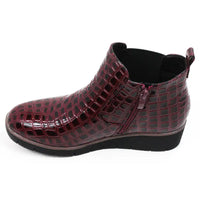 Burgundy crocodile-patterned boot. View showing zipper for fastening.