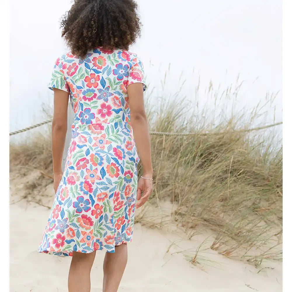 Person wearing a colorful floral dress on a beach