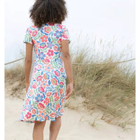 Person wearing a colorful floral dress on a beach