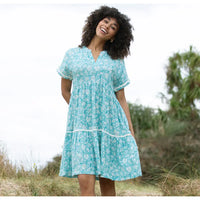 Front of a pale blue dress with a floral paisley print in white. Short sleeves, knee length and v neckline. 