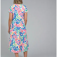 Back  of a white based dress with a large rainbow coloured paisley print. Dress has short sleeves and falls to below the knee.