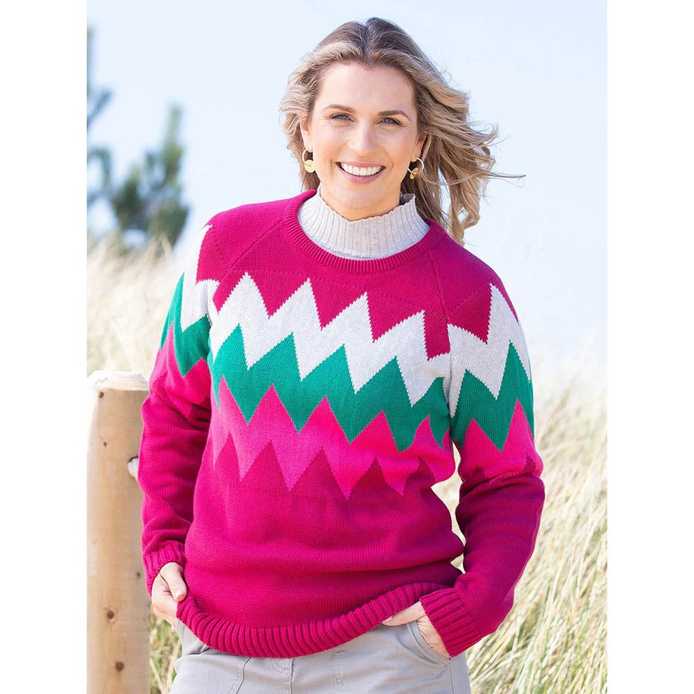 Kite bright cerise jumper with pink, green and light grey zig zag pattern. Front view.