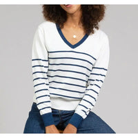 White jumper with horizontal navy stripes and a navy trim on V neckline and cuffs of long sleeves. 