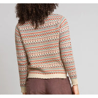 A person shown from the back wearing a long-sleeve knit sweater with a multicolor Fair Isle pattern in cream, rust orange, and teal, paired with brown trousers, against a light gray studio background.