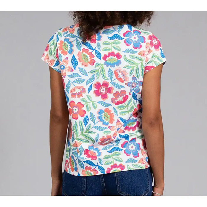 Person wearing a colorful floral-patterned shirt against a gray background