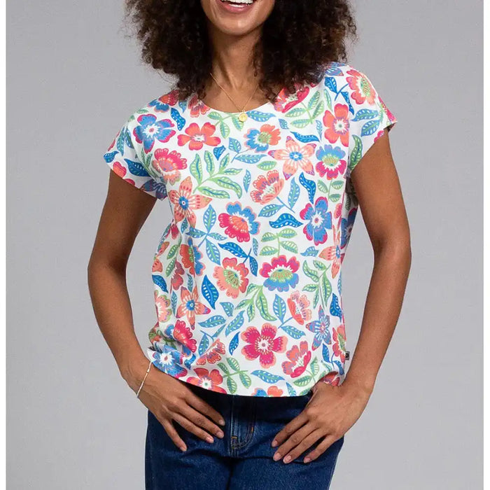 Woman wearing a colorful floral t-shirt against a gray background