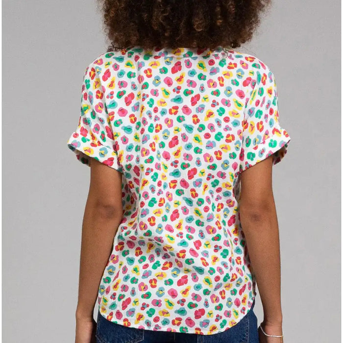 Person wearing a colorful patterned shirt on a gray background