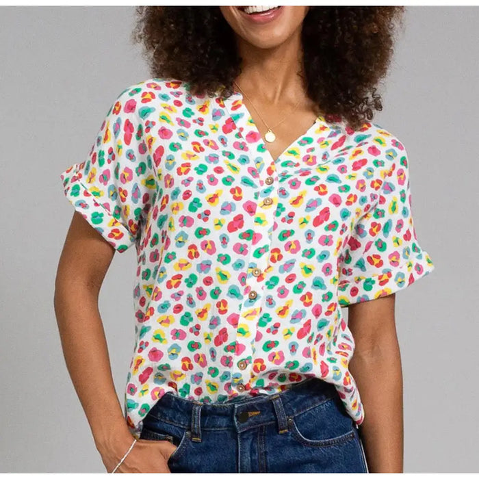 Person wearing a colorful patterned shirt with a gray background