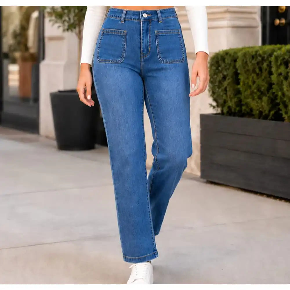 Person wearing blue jeans standing outdoors with a blurred background