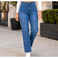 Person wearing blue jeans standing outdoors with a blurred background