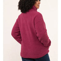 A woman wearing a dusty rose fleece quarter-zip pullover jacket, shown from a back-three-quarter angle against a plain off-white background.