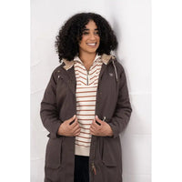 Person wearing a brown coat over a striped shirt against a white background